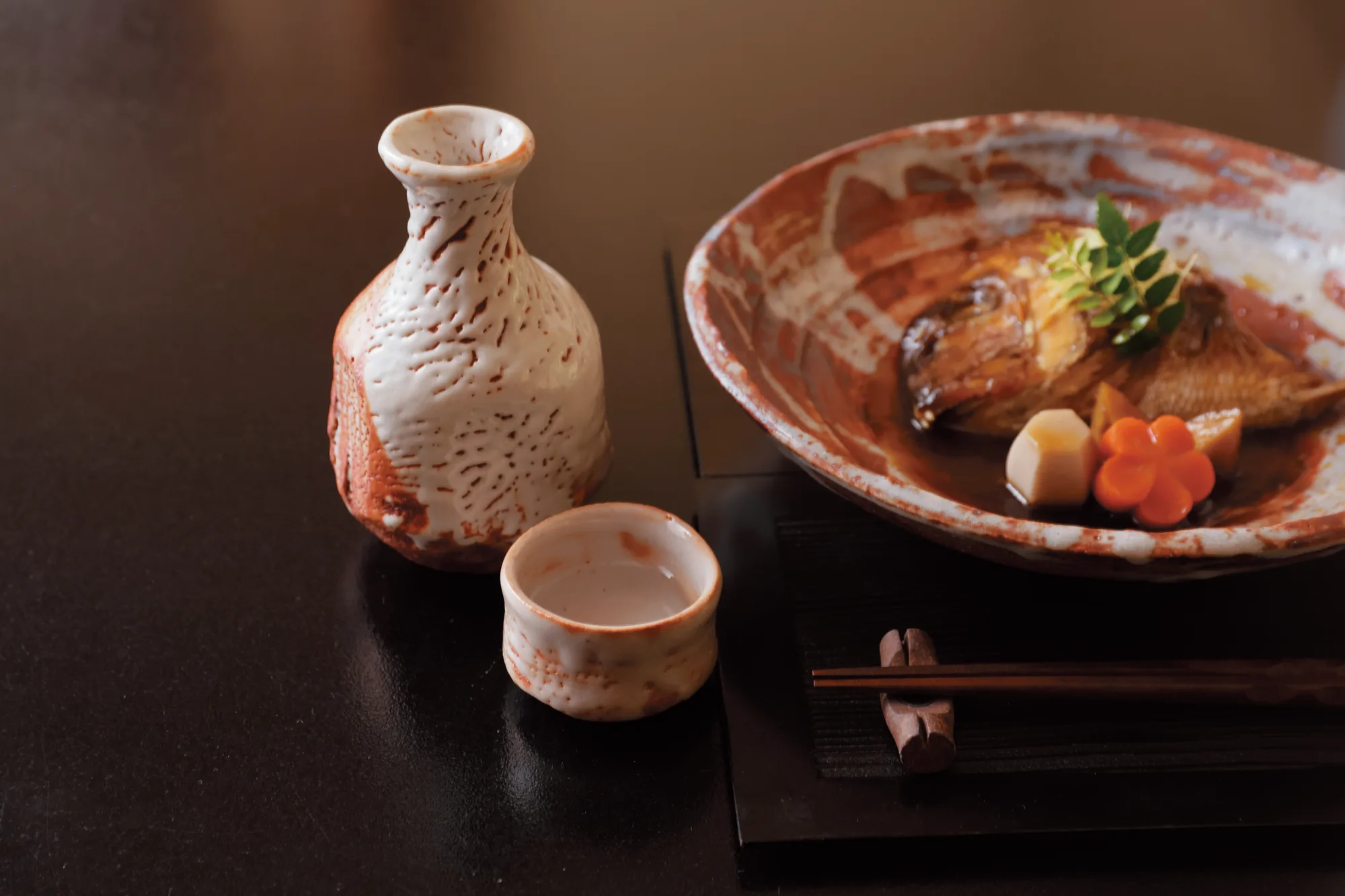 膳の上の、志野の徳利とぐい呑みと焼き物の皿